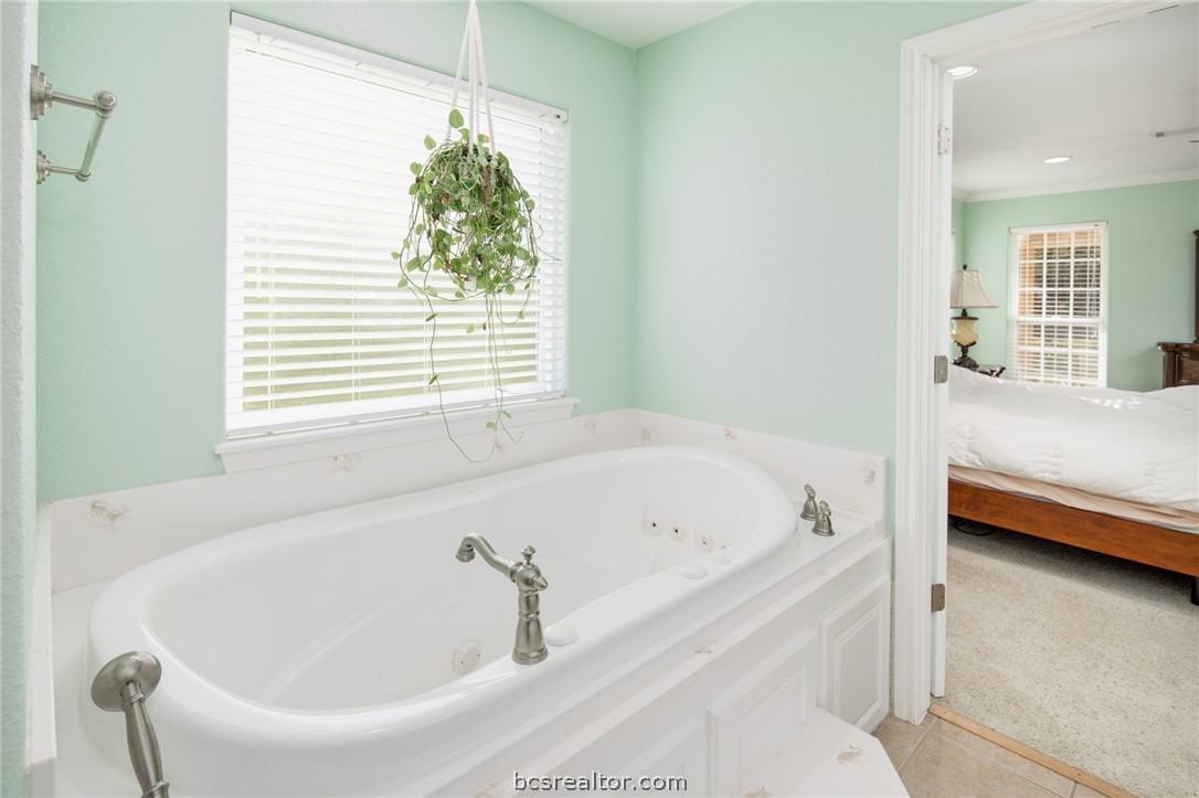 209 Ranchette Court Bryan, TX 77808 - Photo 19 of 37 a bathroom with a bathtub and a window