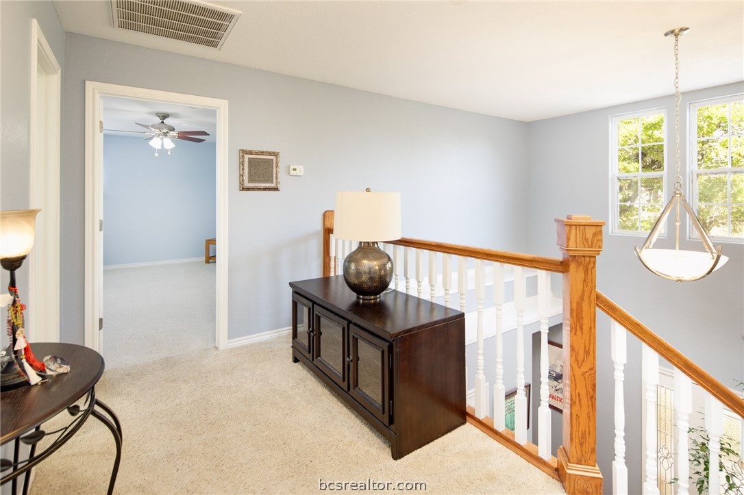 209 Ranchette Court Bryan, TX 77808 - Photo 20 of 37 a view of a hallway to a livingroom with wooden floor and furniture