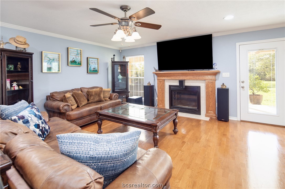 209 Ranchette Court Bryan, TX 77808 - Photo 8 of 37 a living room with furniture a flat screen tv and a fireplace