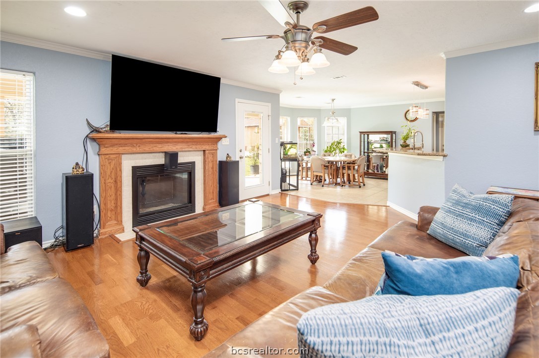 209 Ranchette Court Bryan, TX 77808 - Photo 9 of 37 a living room with furniture a flat screen tv and a fireplace