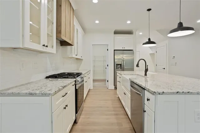 a spacious bathroom with a granite countertop sink a mirror and a shower