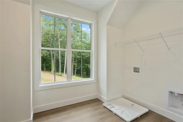 an empty room with wooden floor and ceiling fan