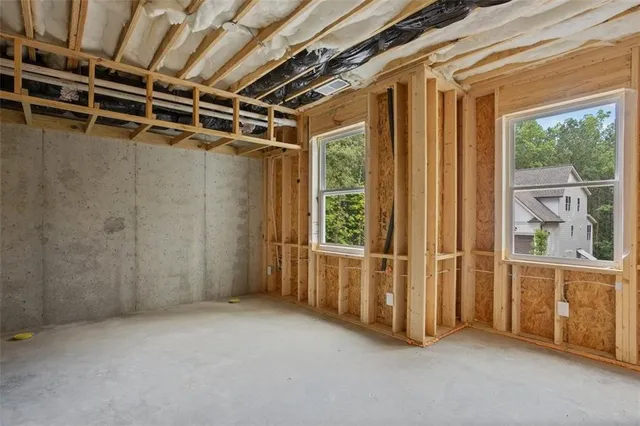 a view of a white house next to a road with large trees