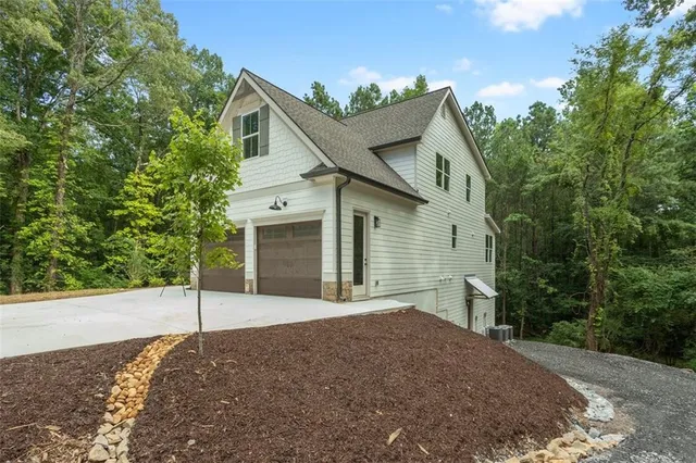 a view of a lush green forest with trees and some houses