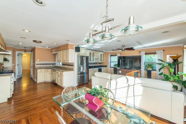 a large white kitchen with lots of counter space and chandelier