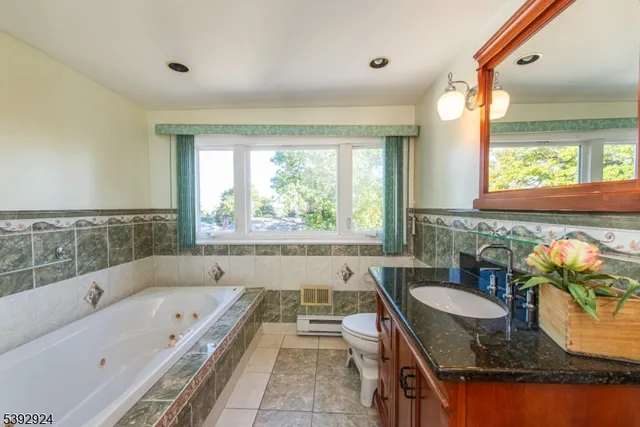 a bathroom with a granite countertop tub and a sink