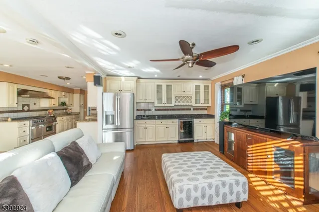 a living room with stainless steel appliances furniture and a kitchen view