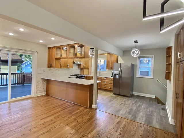 a large kitchen with stainless steel appliances granite countertop a large counter top and a wooden floors