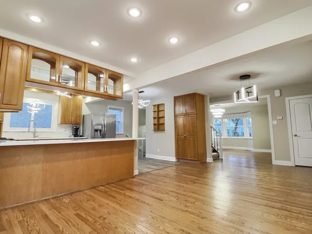 a view of a living room and kitchen with furniture wooden floor and a window