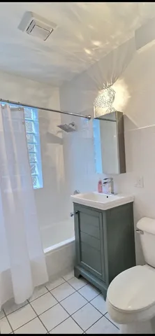 a bathroom with a sink vanity mirror and toilet