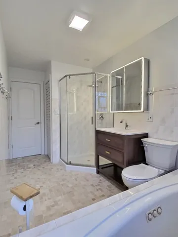 a bathroom with a sink a toilet and shower