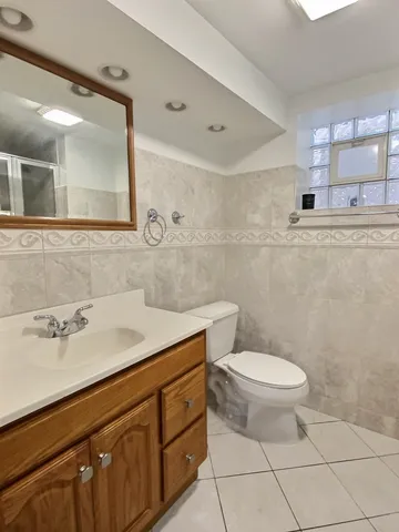 a bathroom with a sink a toilet and mirror