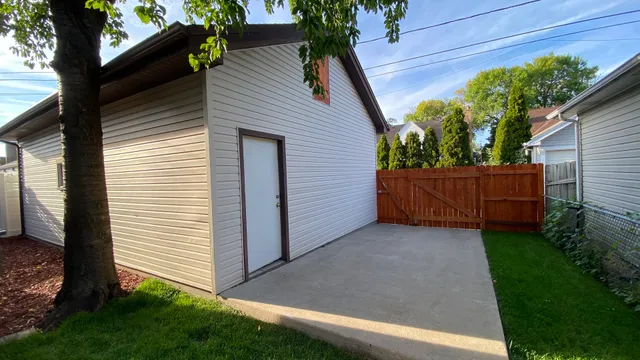 a view of backyard with potted plants and wooden fence