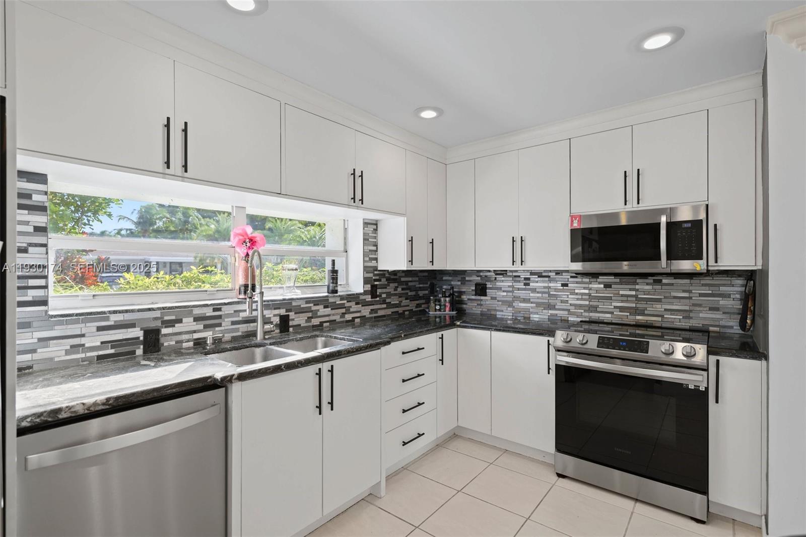 4841 Northeast 29th Avenue Lighthouse Point, FL 33064 - Photo 11 of 50 a kitchen with stainless steel appliances granite countertop a sink and a stove