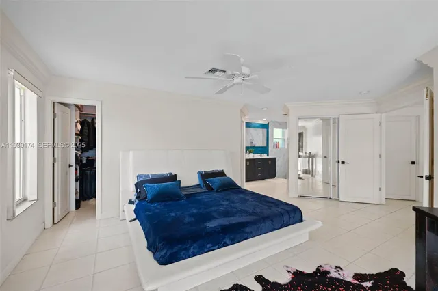 a spacious bedroom with a large bed and a chandelier