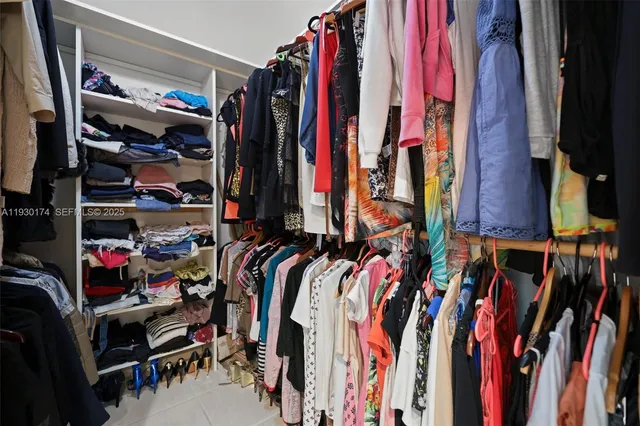 a view of walk in closet with clothes and shoes