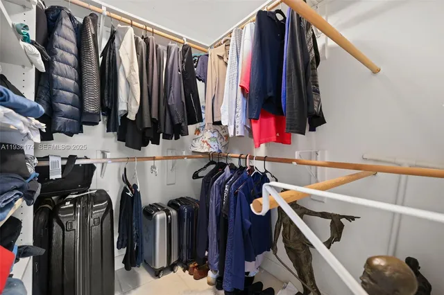 a view of walk in closet with clothes and shoes