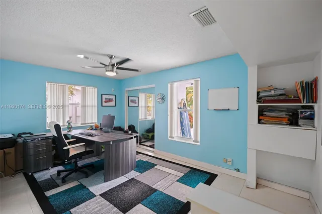 a view of a workspace with furniture and a window