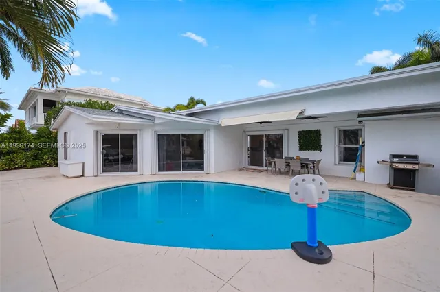 a view of a house with swimming pool and sitting area