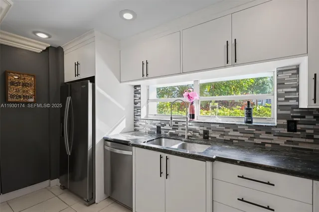 a kitchen with stainless steel appliances granite countertop a refrigerator and a sink