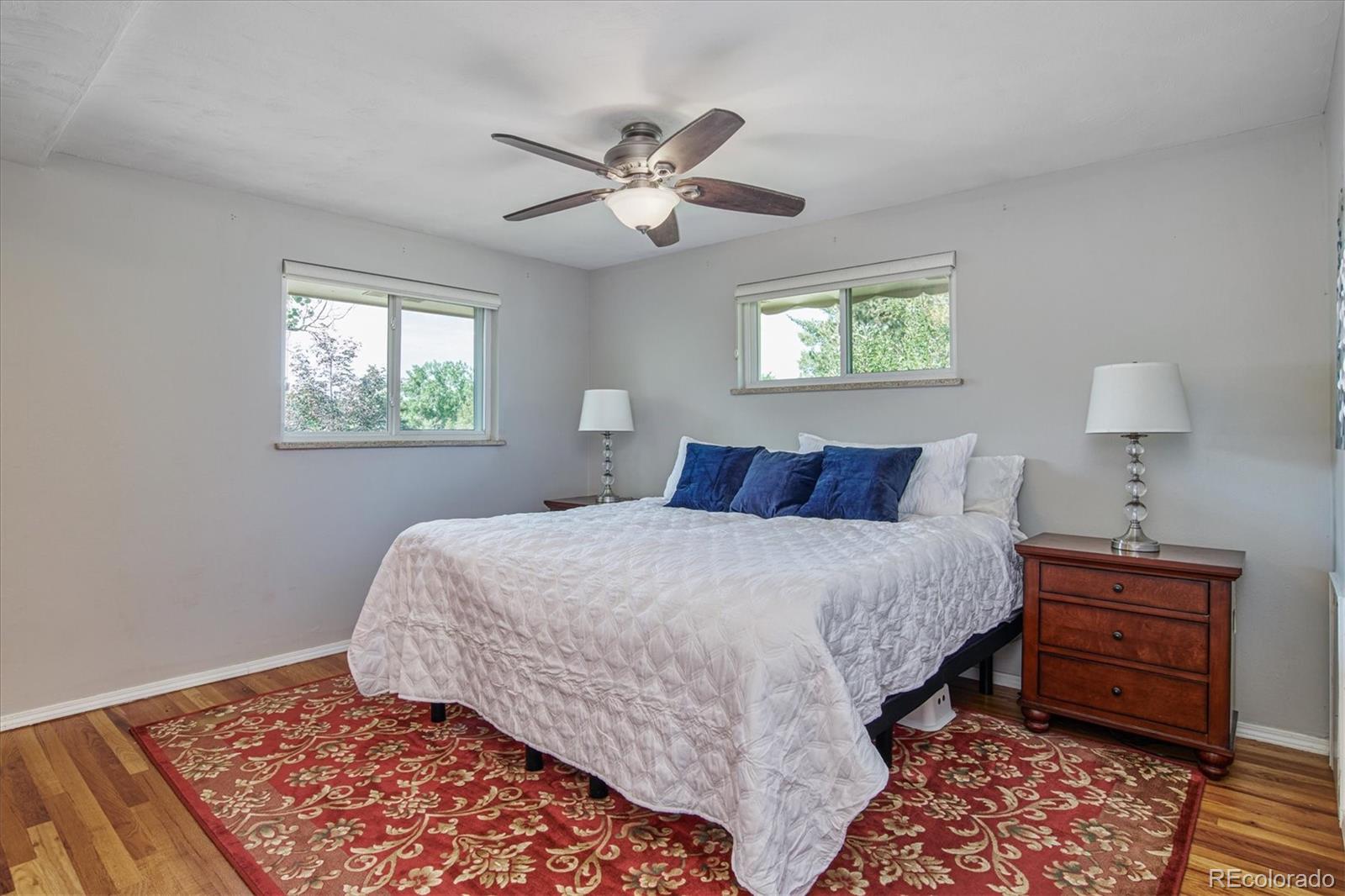 6526 South Elizabeth Way Centennial, CO 80121 - Photo 13 of 38 a bedroom with a bed and a lamp on dresser