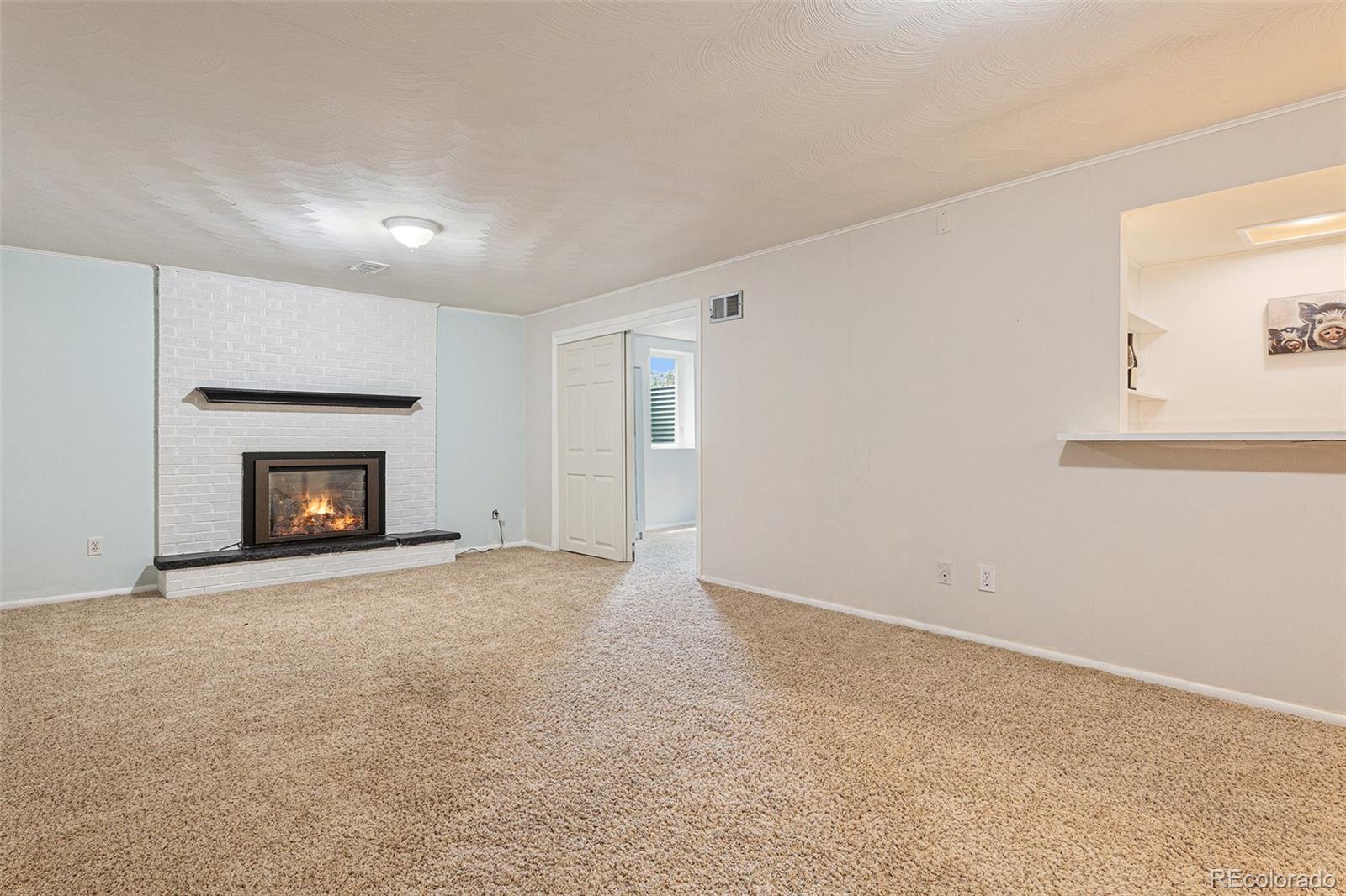 6526 South Elizabeth Way Centennial, CO 80121 - Photo 22 of 38 a view of an empty room with a fireplace and a window