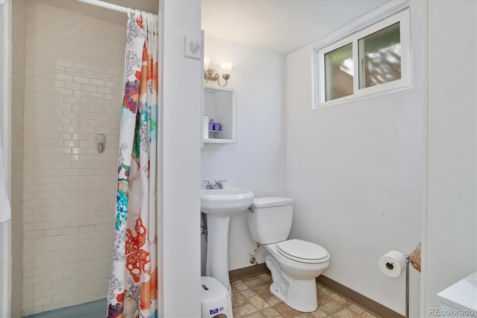 6526 South Elizabeth Way Centennial, CO 80121 - Photo 24 of 38 a white toilet sitting next to a shower curtain