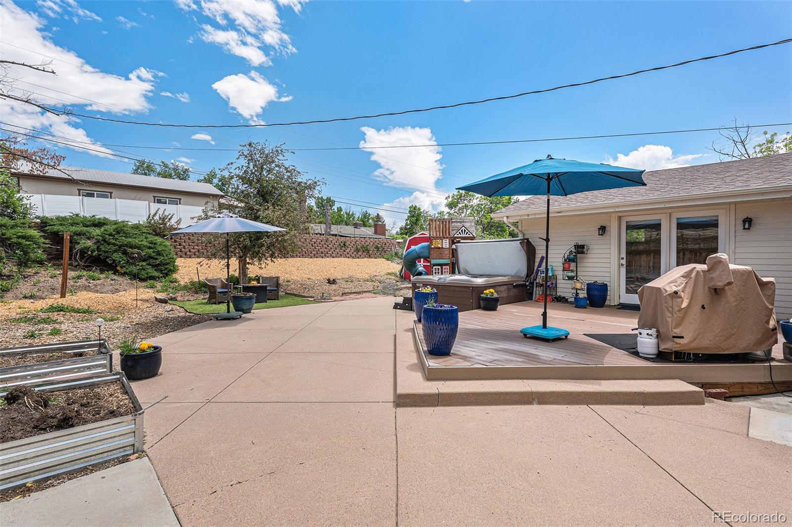 6526 South Elizabeth Way Centennial, CO 80121 - Photo 31 of 38 a view of a patio with dining table and chairs under an umbrella