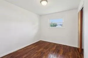 an empty room with wooden floor and closet