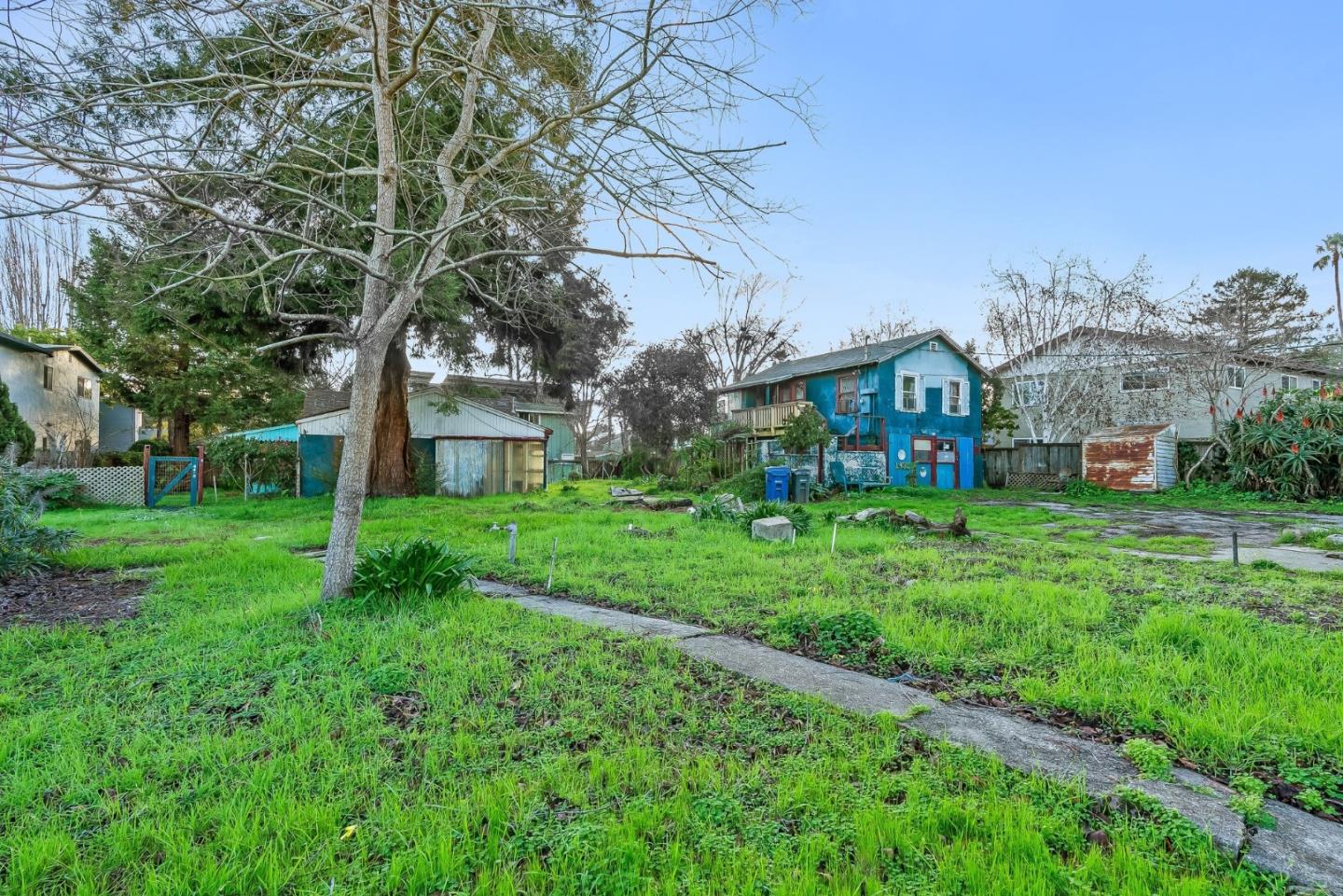a view of house with a yard and potted plants