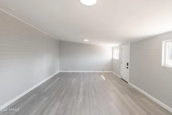 an empty room with wooden floor and windows