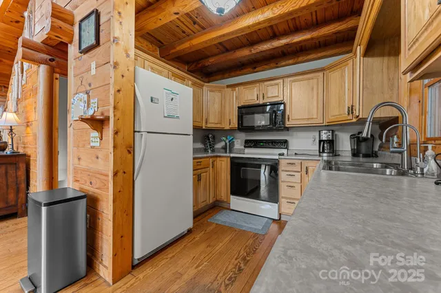 a kitchen with stainless steel appliances granite countertop a refrigerator a stove top oven a sink and dishwasher