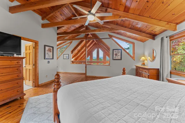 a bedroom with a bed and a flat tv screen on the dresser