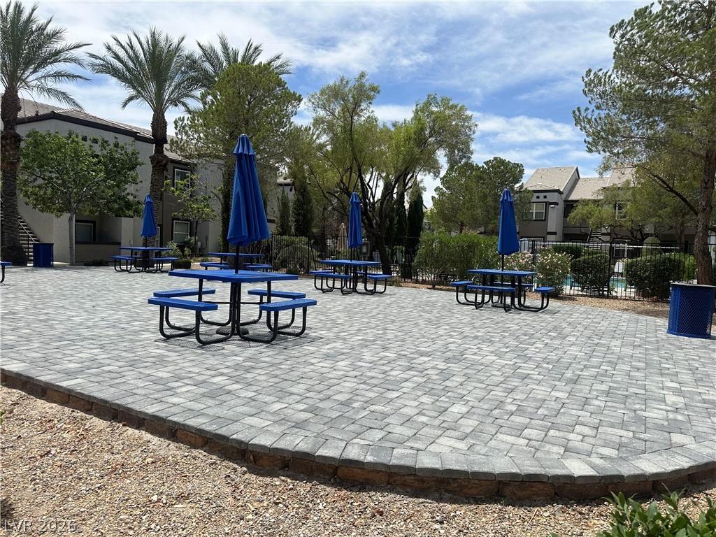 7255 West Sunset Road, Unit 2006 Las Vegas, NV 89113 - Photo 22 of 24 Relax in the community area, featuring picnic tables under vibrant blue umbrellas.