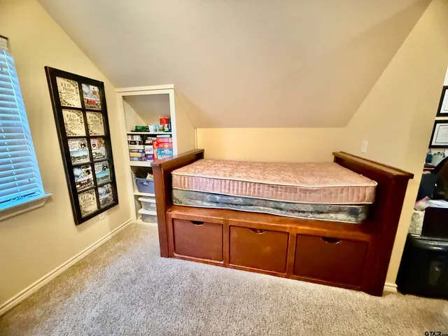 a bedroom with a bed and a dresser next to a window