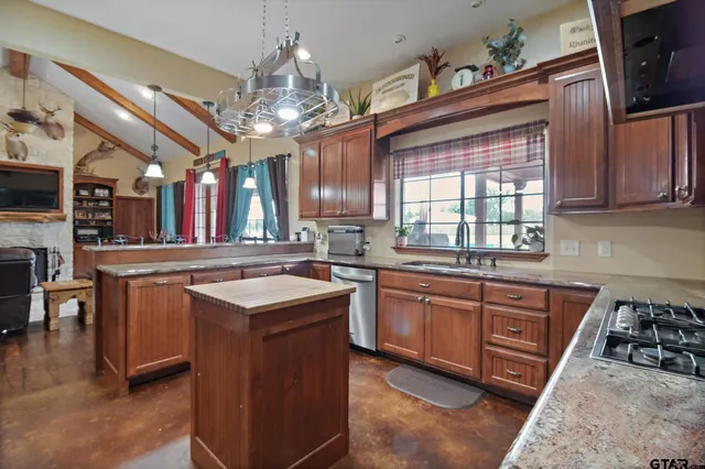 a kitchen with granite countertop a sink stove cabinets and refrigerator