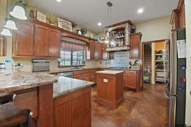 a view of a dining room with furniture a kitchen and chandelier