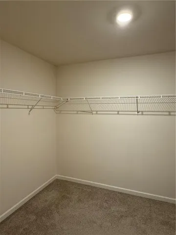 a white toilet sitting next to a white wall