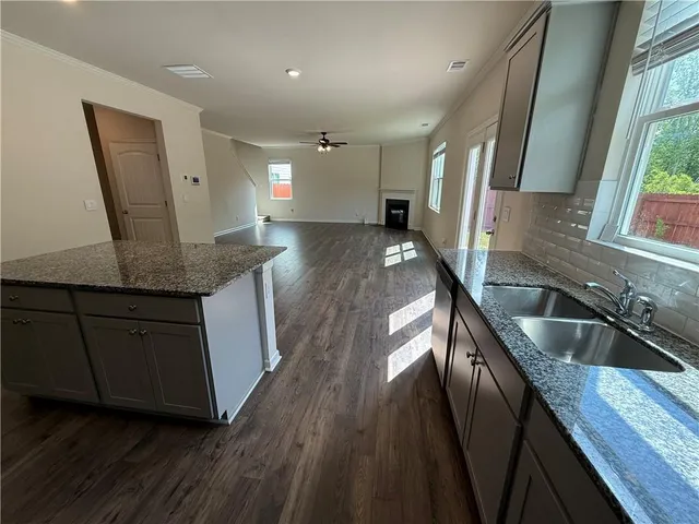 a kitchen with granite countertop a sink a counter space and cabinets