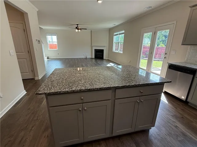a kitchen with granite countertop wooden cabinets a sink and dishwasher