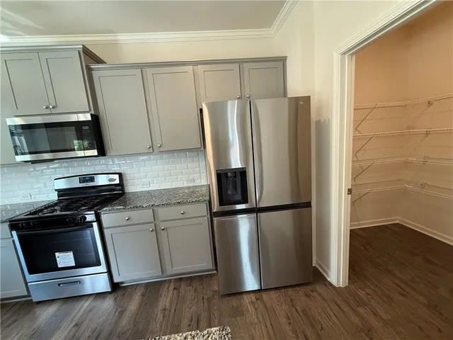 a kitchen with a refrigerator stove and wooden cabinets