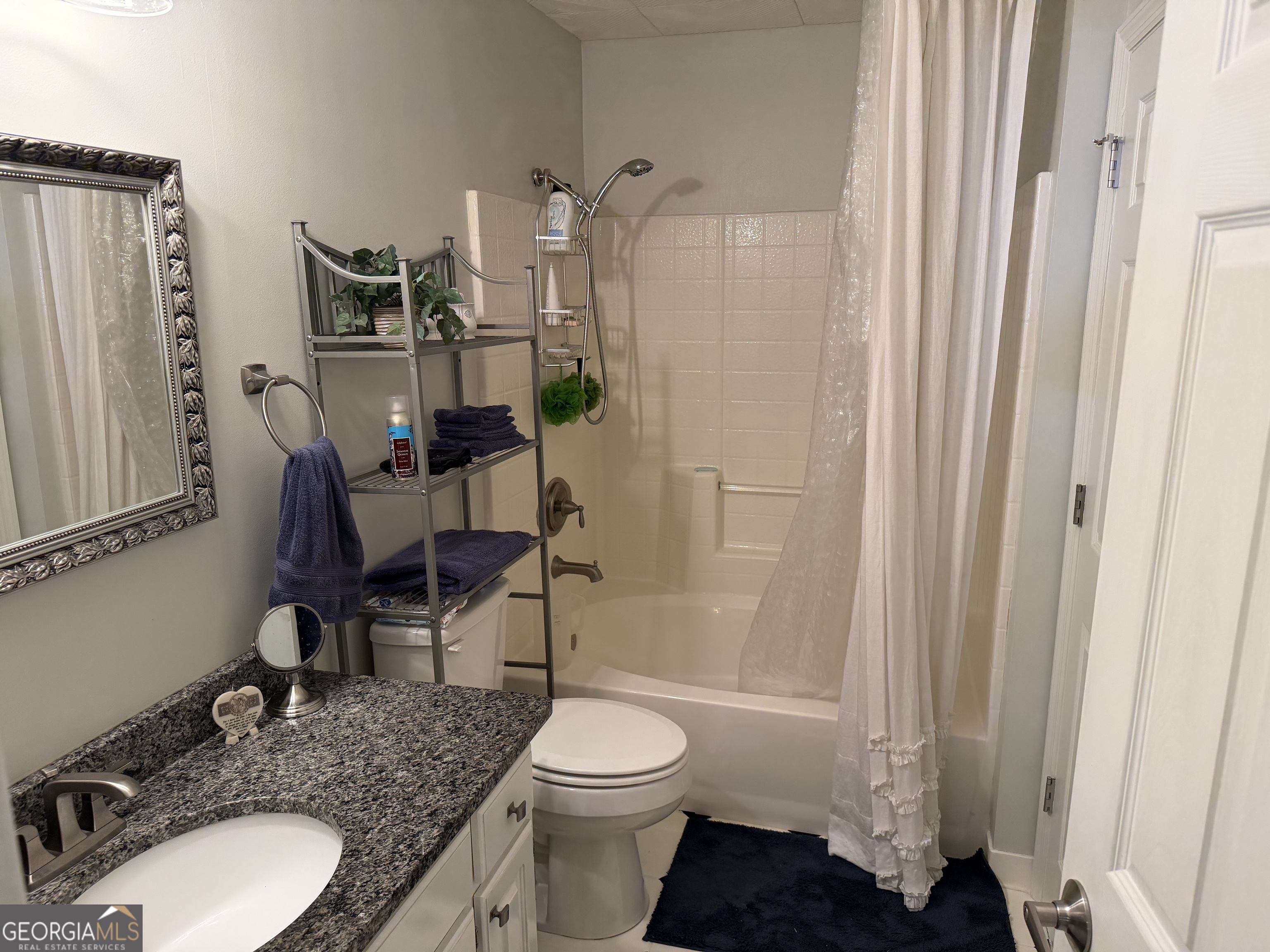 848 Tanglewood Circle Dublin, GA 31021 - Photo 18 of 21 a bathroom with a granite countertop sink toilet a mirror and shower