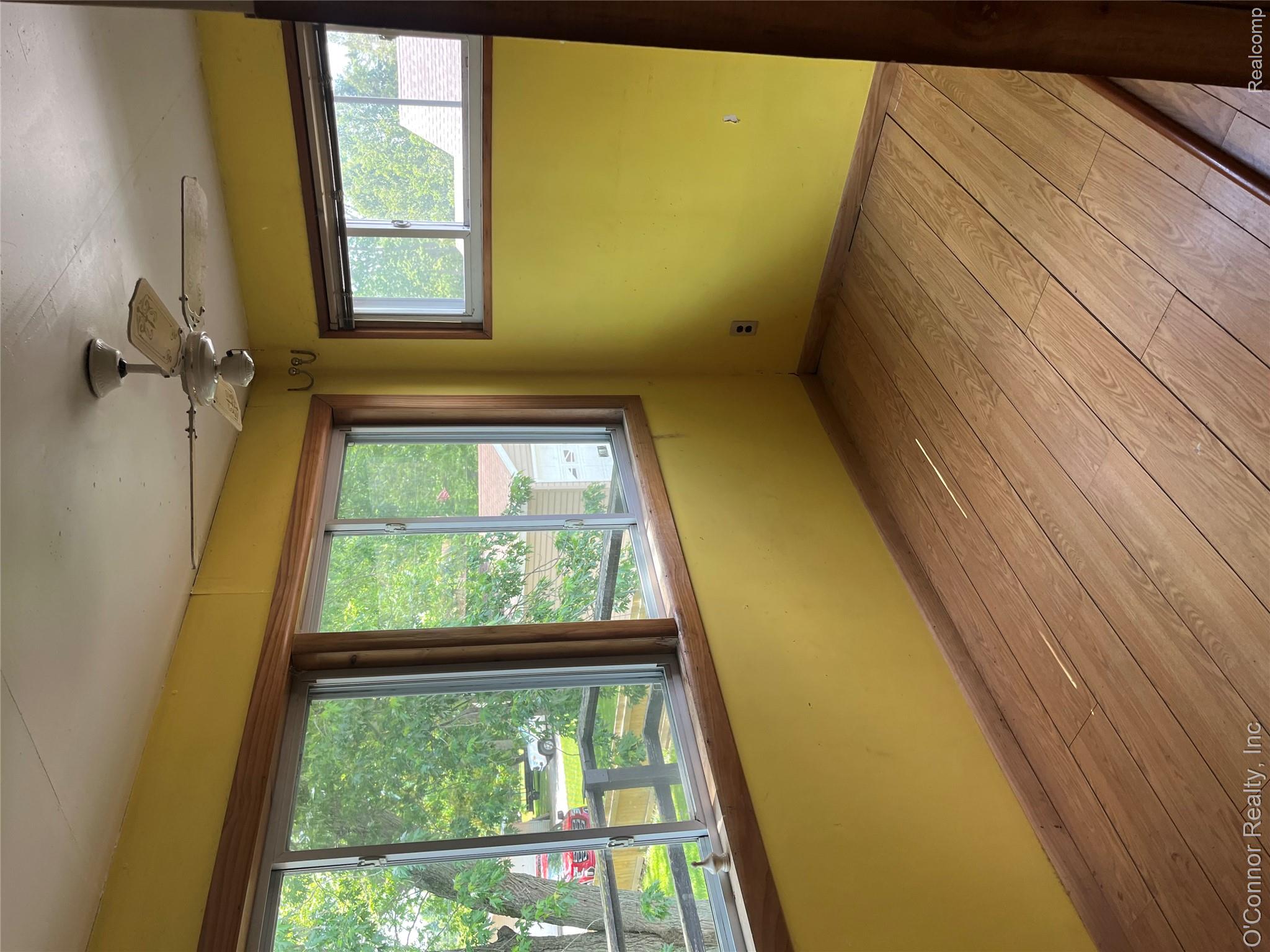 3909 Burtch Road Fort Gratiot, MI 48059 - Photo 16 of 19 Room featuring wood-finish flooring, multiple windows with wood trim, and an overhead ceiling fan