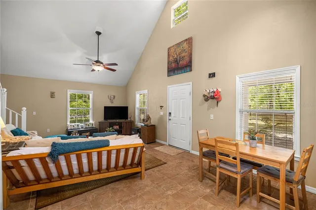 a living room with furniture kitchen view and a large window