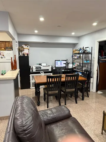 a dining room with furniture and kitchen view