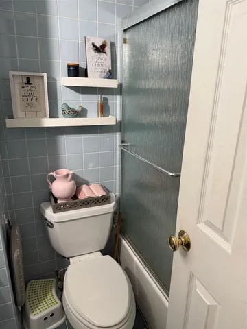 a white toilet sitting next to a bathroom sink and vanity