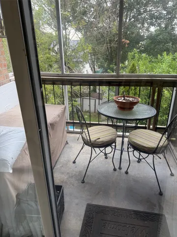 a view of a balcony with chairs and wooden fence