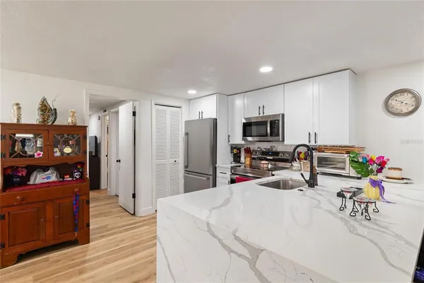 a living room with furniture a flat screen tv and kitchen view