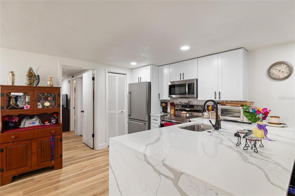 5707 Tennessee Avenue New Port Richey, FL 34652 - Photo 5 of 26 a living room with stainless steel appliances furniture a flat screen tv and a refrigerator