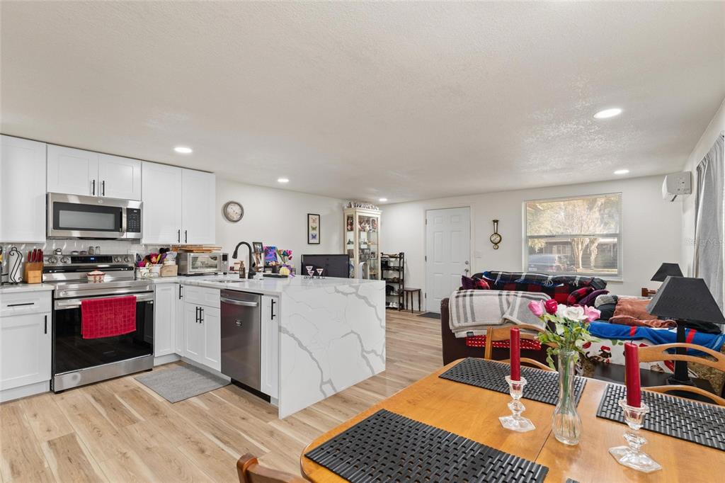 5707 Tennessee Avenue New Port Richey, FL 34652 - Photo 6 of 26 a living room with furniture a flat screen tv and kitchen view